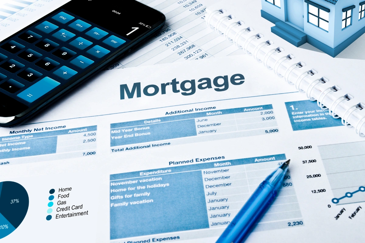 Mortgage planning concept with calculator, financial documents, and model house illustrating Portland homebuyer mortgage rate outlook for December 2025 and 2026