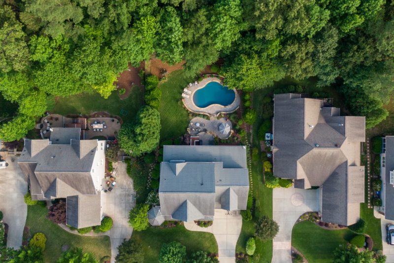 Aerial view of a suburban neighborhood featuring green backyards and a swimming pool in Wake Forest, NC.